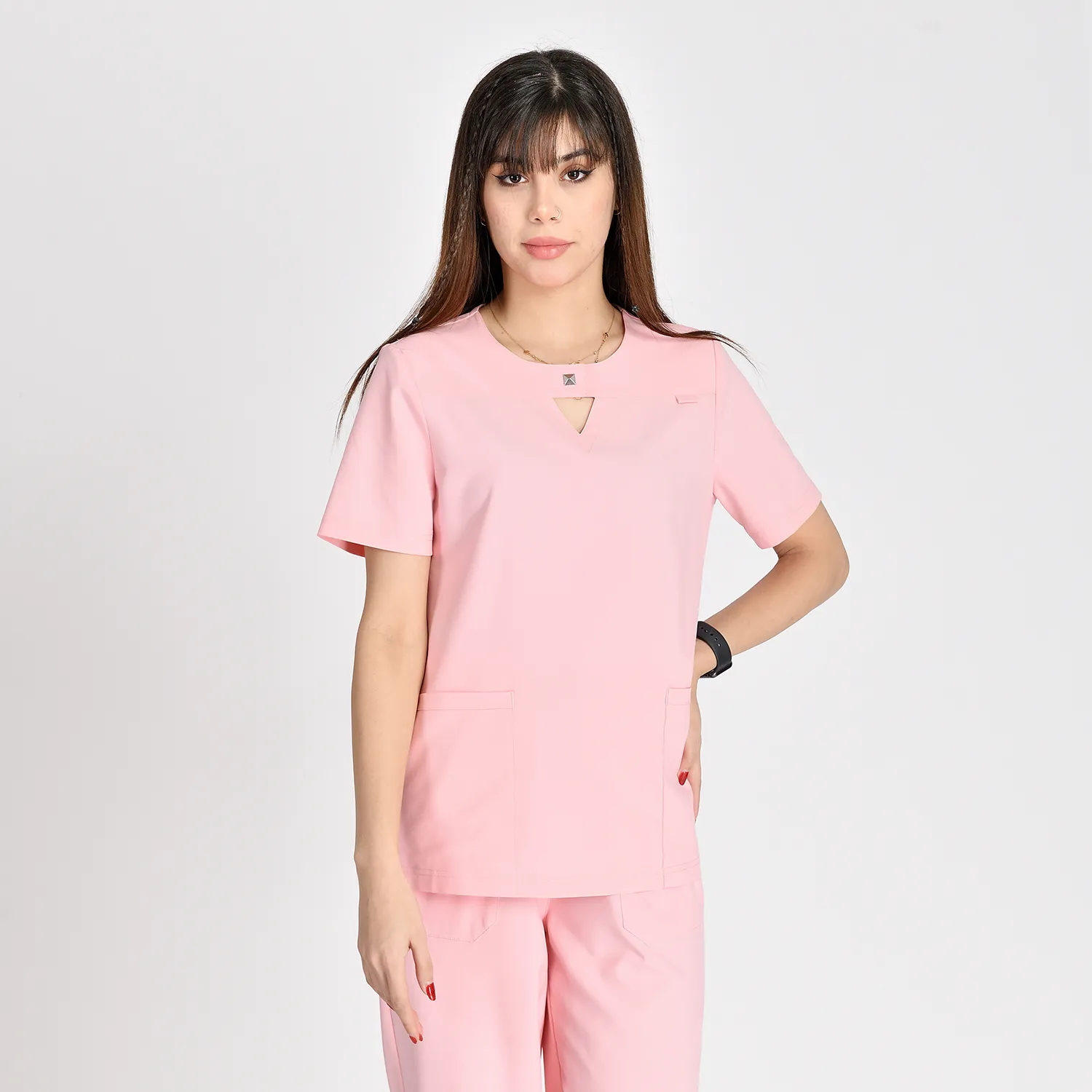 Close-up view of a women's pink V-neck medical scrub top with pockets, offering a professional and comfortable fit for healthcare workers.